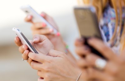 several hands holding mobile devices