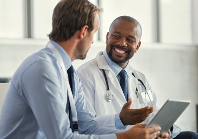 Two Physicians having a discussion while using a tablet device