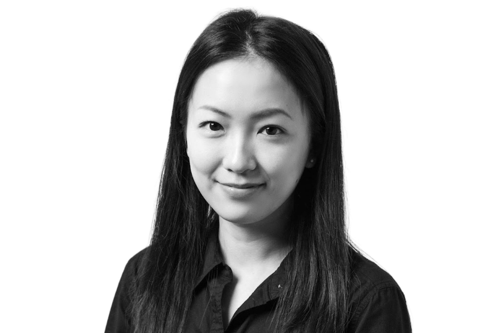 A woman with long, straight hair wearing a dark button-up shirt, facing forward and smiling slightly against a plain background.
