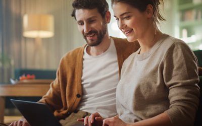 Man and woman in living room looking at laptop