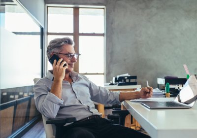 Man working on computer while talking on the phone