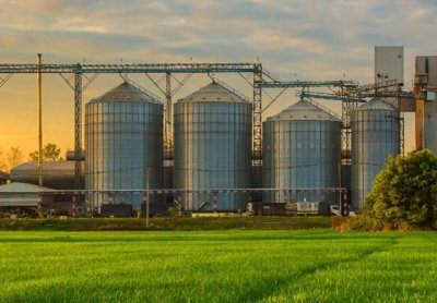 Three silos next to each other  across a green field